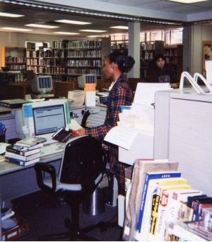 A library staff member helps a patron from the front desk at Brookhaven in the 1980s